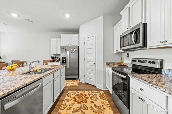 a kitchen with stainless steel appliances granite countertop a refrigerator stove and sink