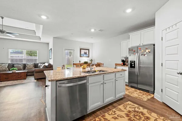 a kitchen with sink refrigerator and microwave