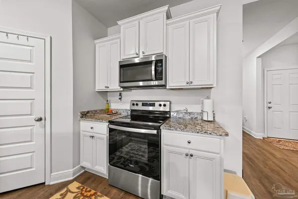 a kitchen with stainless steel appliances granite countertop a stove and a microwave