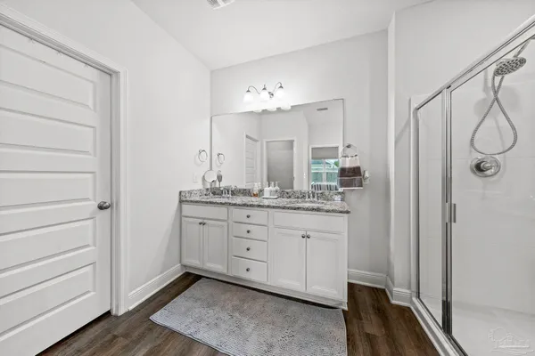 a bathroom with a granite countertop sink a mirror and a shower