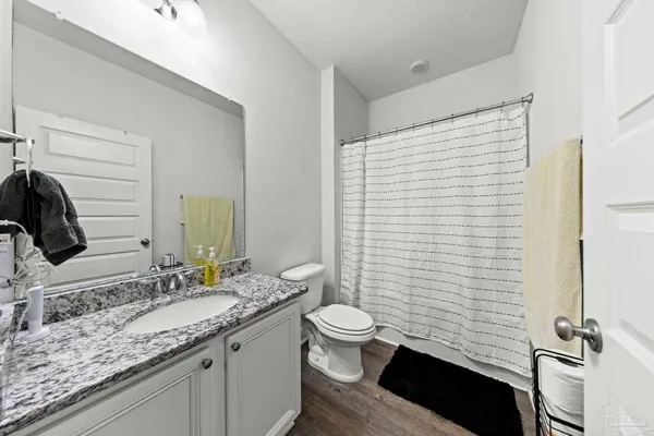 a bathroom with a granite countertop sink toilet and shower