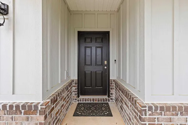 a view of a hallway with wooden floor and a door