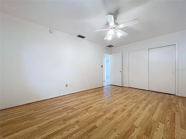 a view of an empty room with window and wooden floor