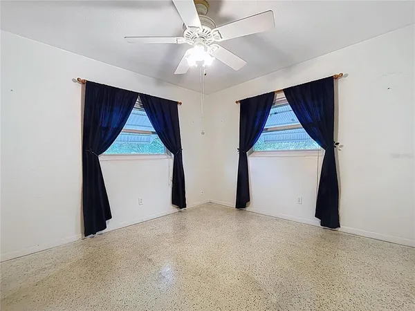 an empty room with windows and cabinet