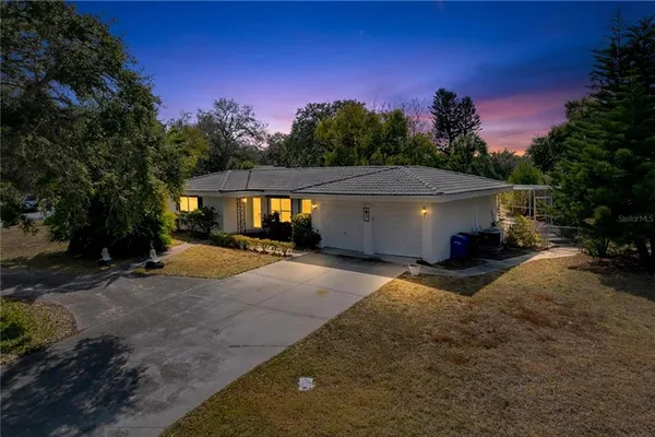 a view of a house with backyard and a tree