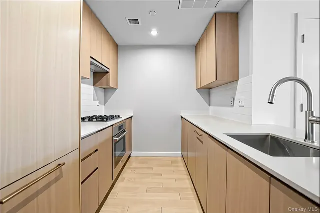 a kitchen with stainless steel appliances granite countertop a sink and a stove top oven
