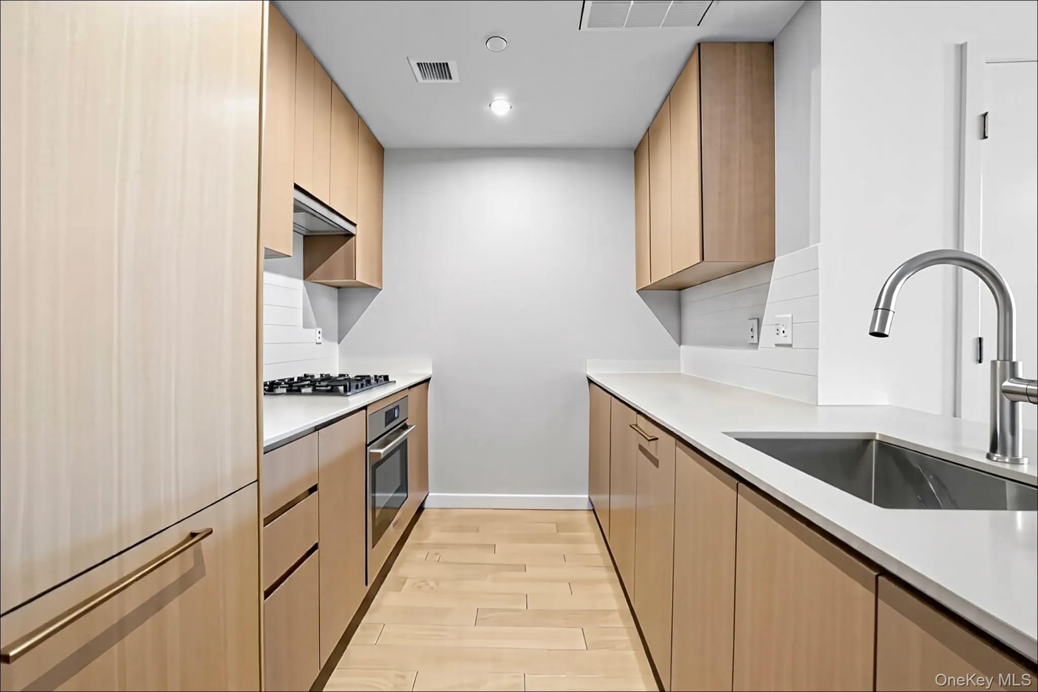 131-02 40th Road, Unit 12G Queens, NY 11354 - Photo 11 of 18 a kitchen with stainless steel appliances granite countertop a sink and a stove top oven
