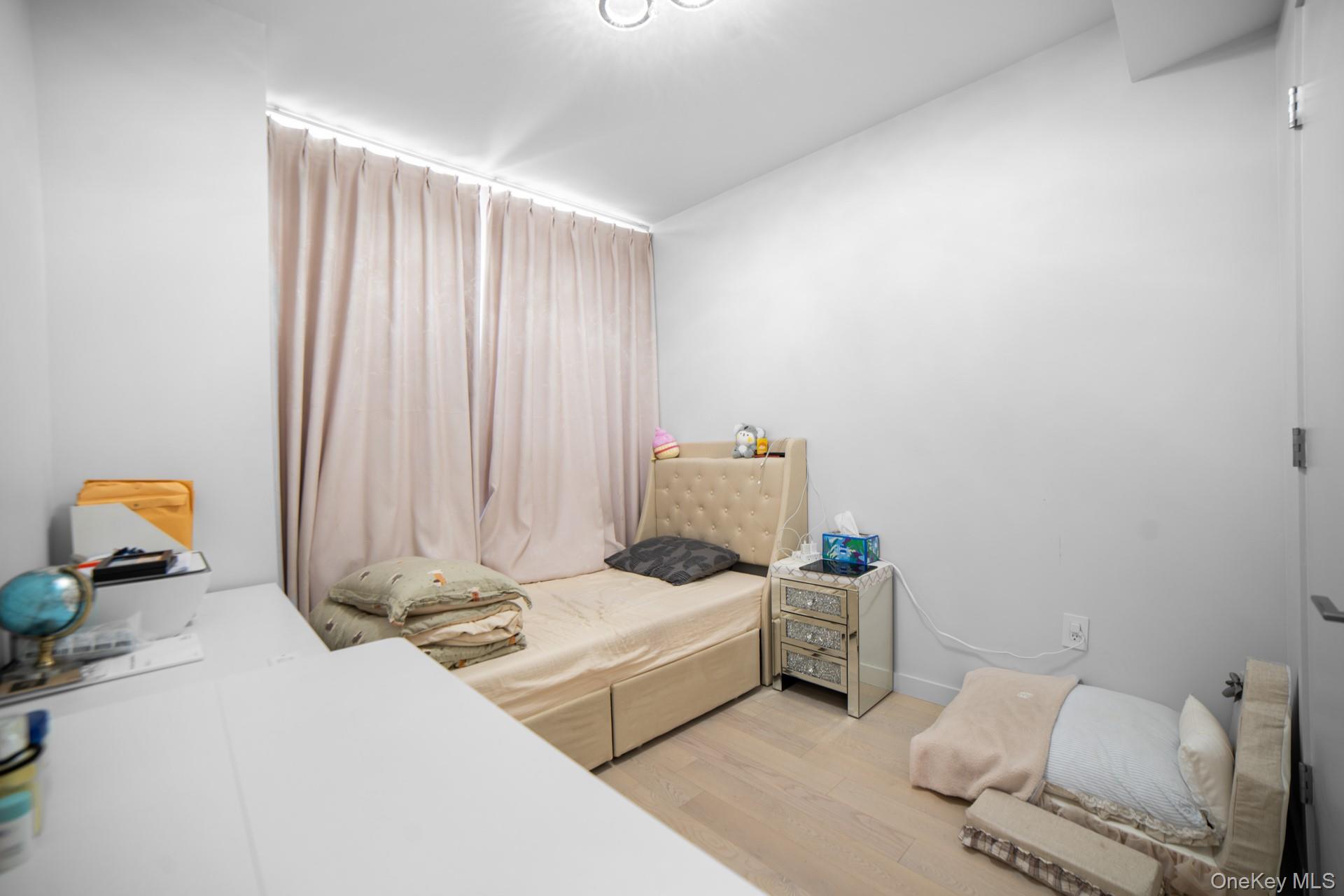 131-02 40th Road, Unit 12G Queens, NY 11354 - Photo 14 of 18 a bedroom with furniture and a bed