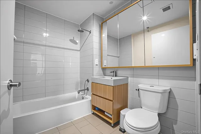 a bathroom with a granite countertop toilet a sink and bathtub