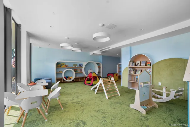 a living room with furniture a table and kitchen view