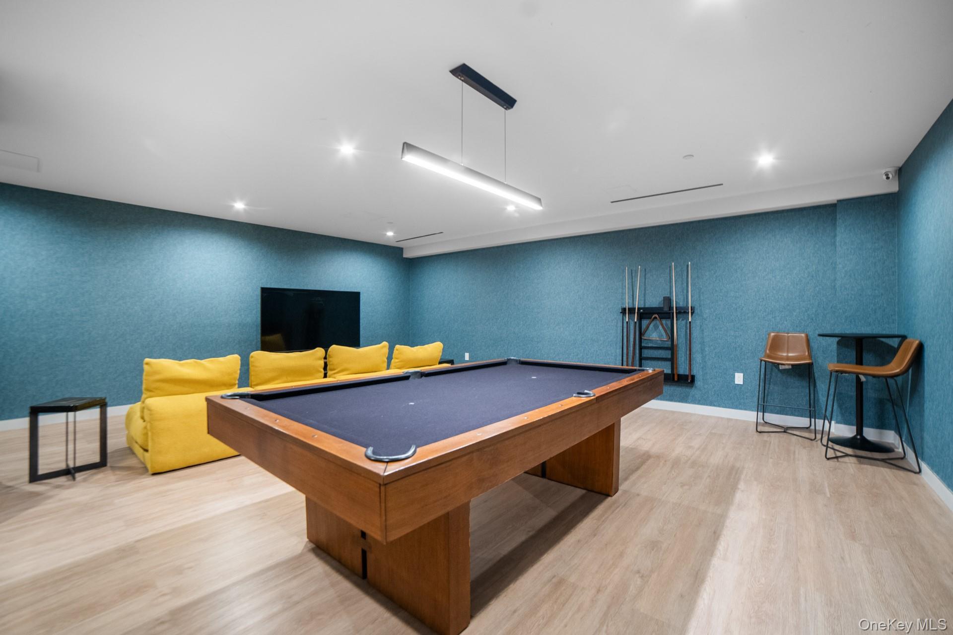 131-02 40th Road, Unit 12G Queens, NY 11354 - Photo 4 of 18 a room with table tennis table and a projector screen