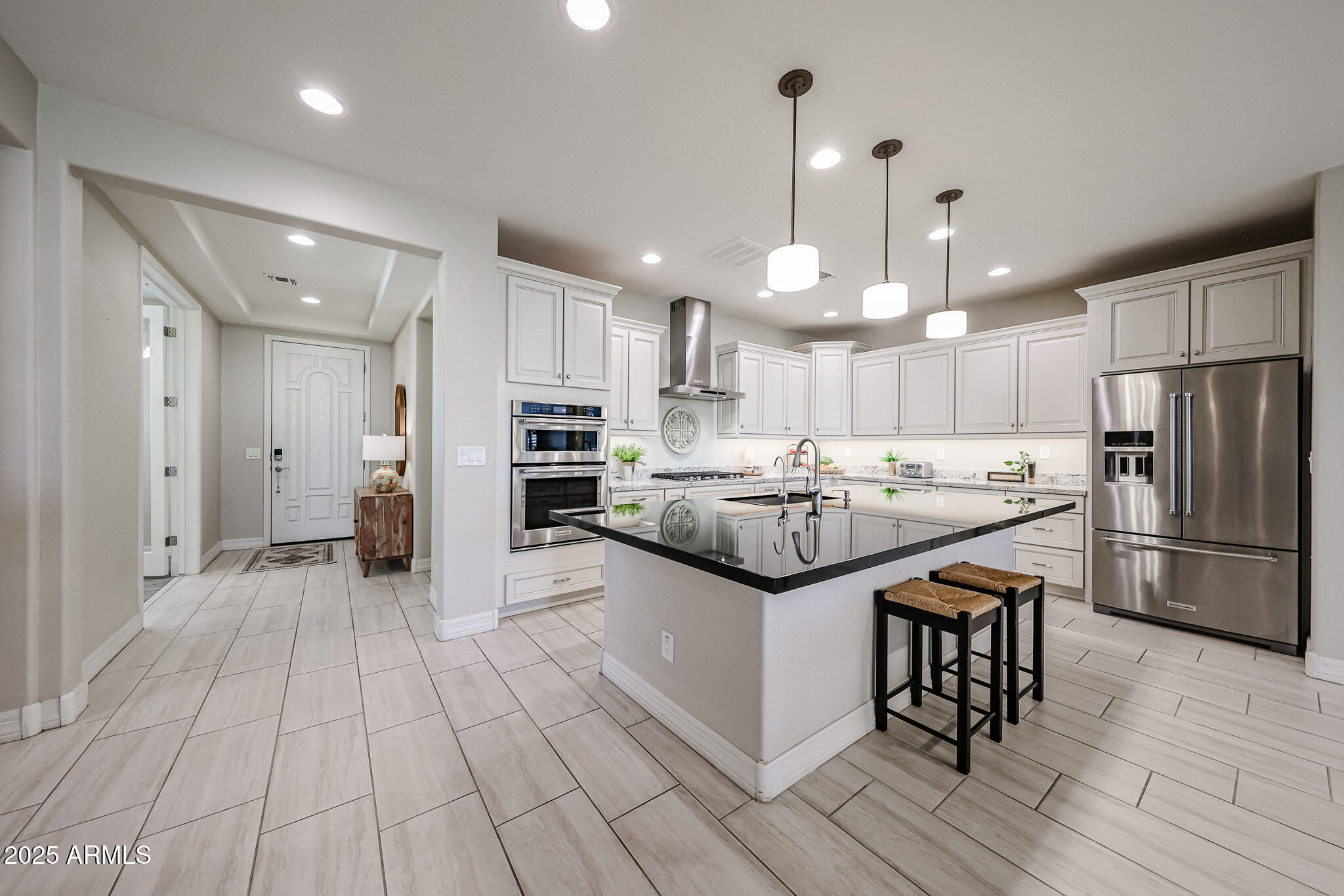 18184 West Deer Creek Road Goodyear, AZ 85338 - Photo 16 of 82 a kitchen with stainless steel appliances kitchen island granite countertop a refrigerator and a stove top oven