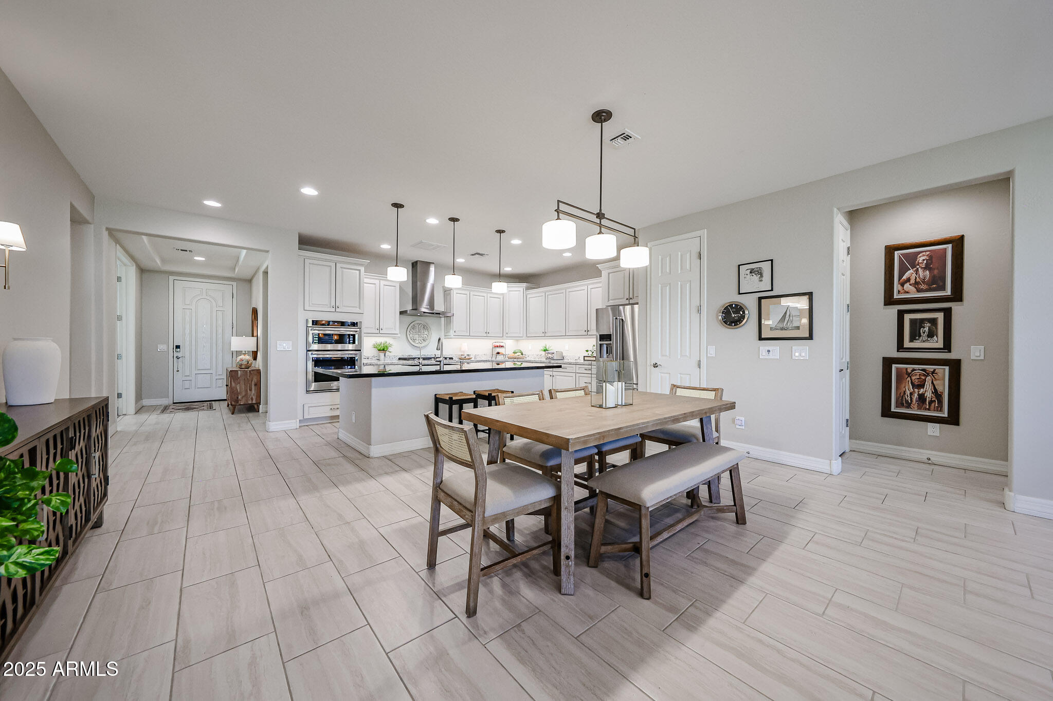18184 West Deer Creek Road Goodyear, AZ 85338 - Photo 22 of 82 a dining hall with stainless steel appliances kitchen island granite countertop a dining table chairs and view kitchen