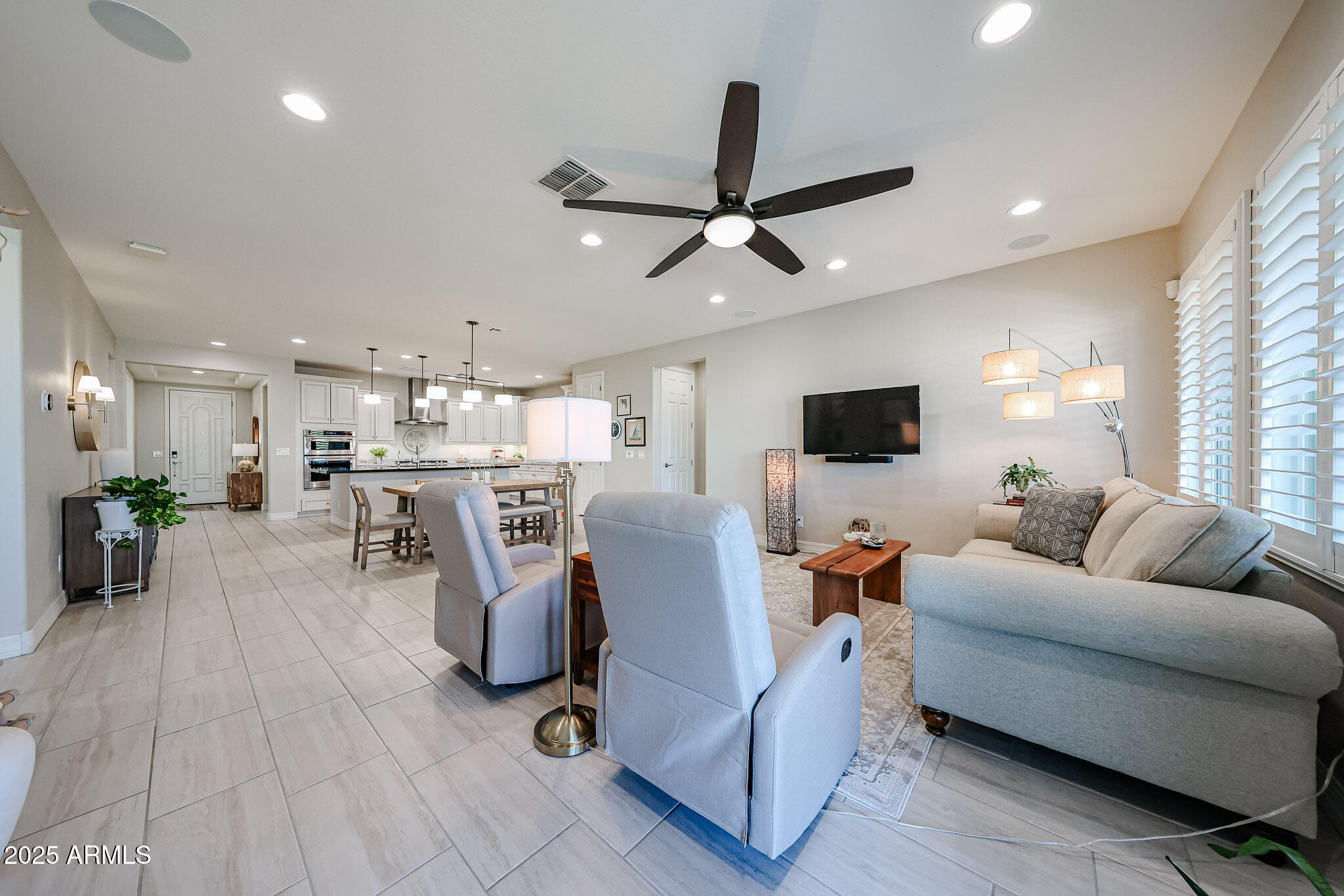 18184 West Deer Creek Road Goodyear, AZ 85338 - Photo 26 of 82 a living room with furniture and a flat screen tv