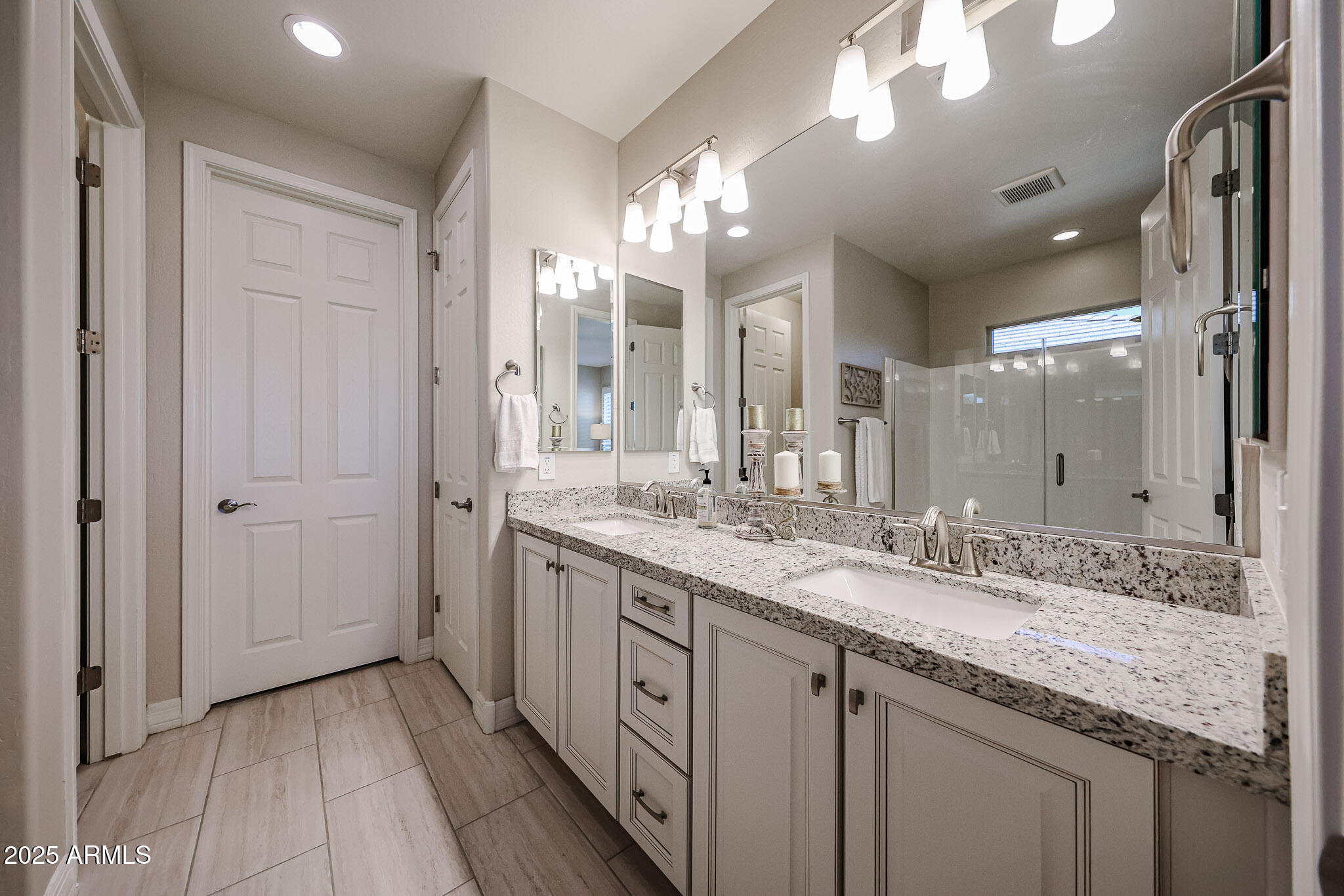 18184 West Deer Creek Road Goodyear, AZ 85338 - Photo 33 of 82 a bathroom with a granite countertop double vanity sink and a mirror