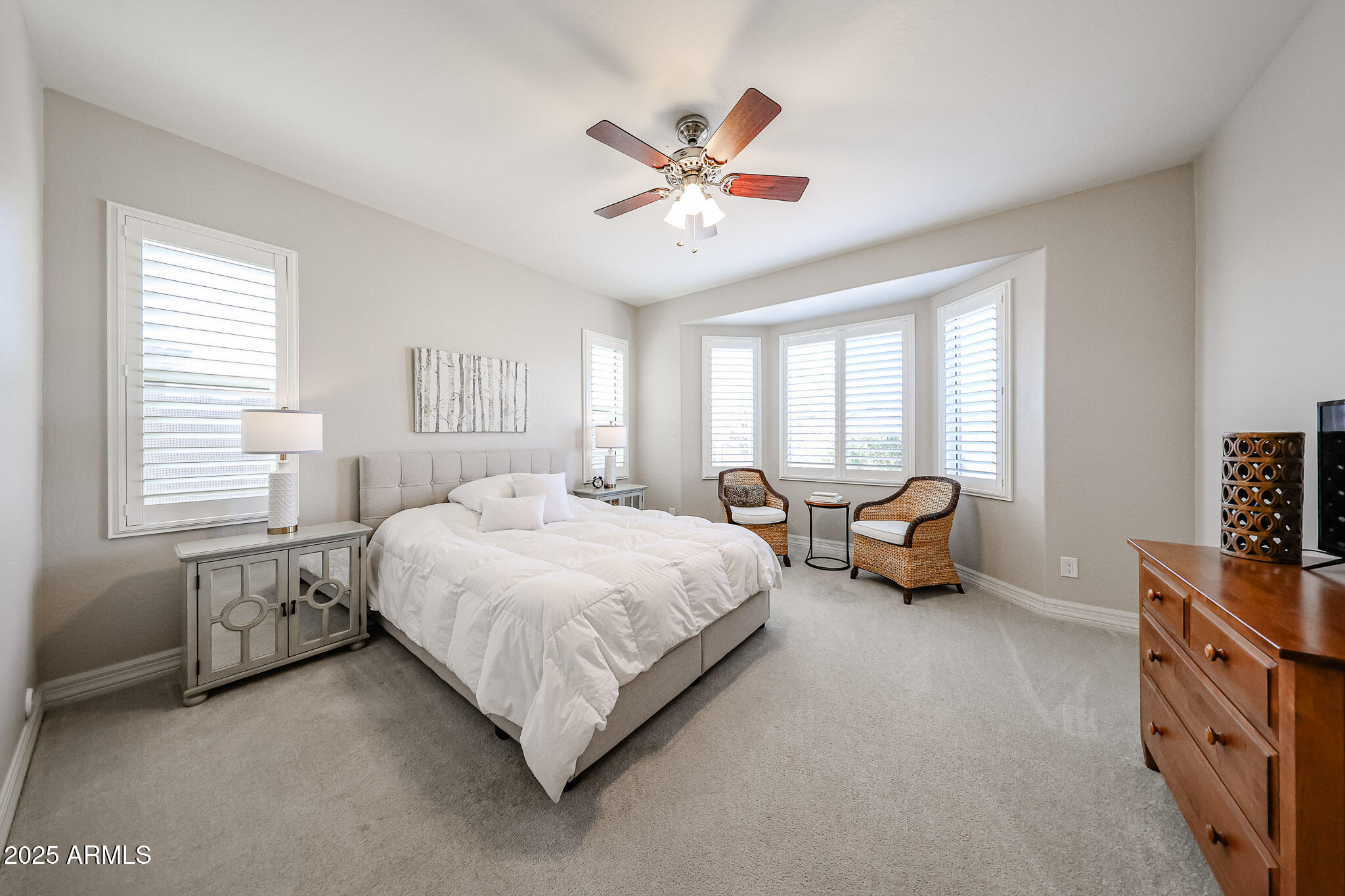 18184 West Deer Creek Road Goodyear, AZ 85338 - Photo 35 of 82 a spacious bedroom with a bed and a chandelier