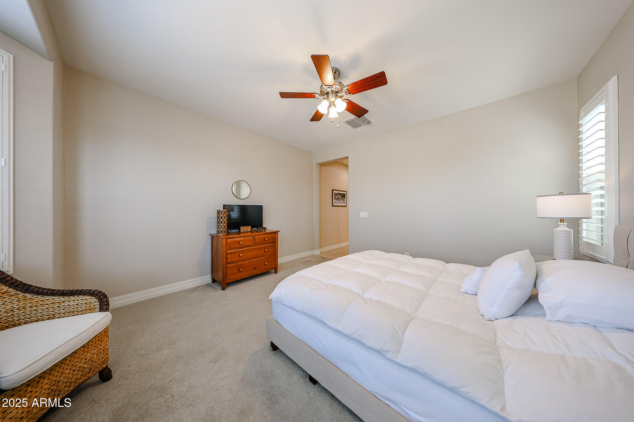 18184 West Deer Creek Road Goodyear, AZ 85338 - Photo 37 of 82 a bedroom with a bed and a chandelier