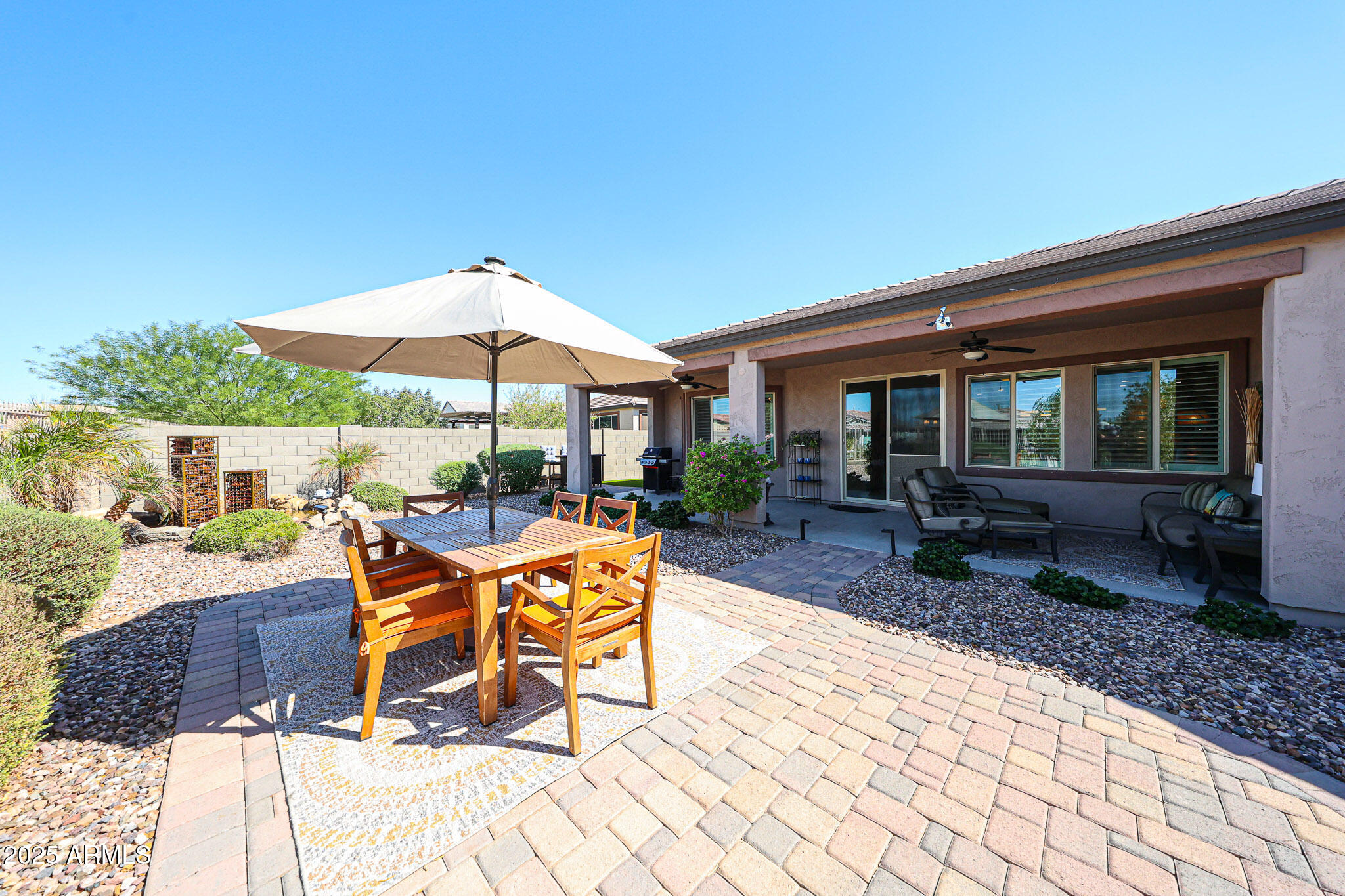 18184 West Deer Creek Road Goodyear, AZ 85338 - Photo 43 of 82 a view of a patio with a table and chairs under an umbrella