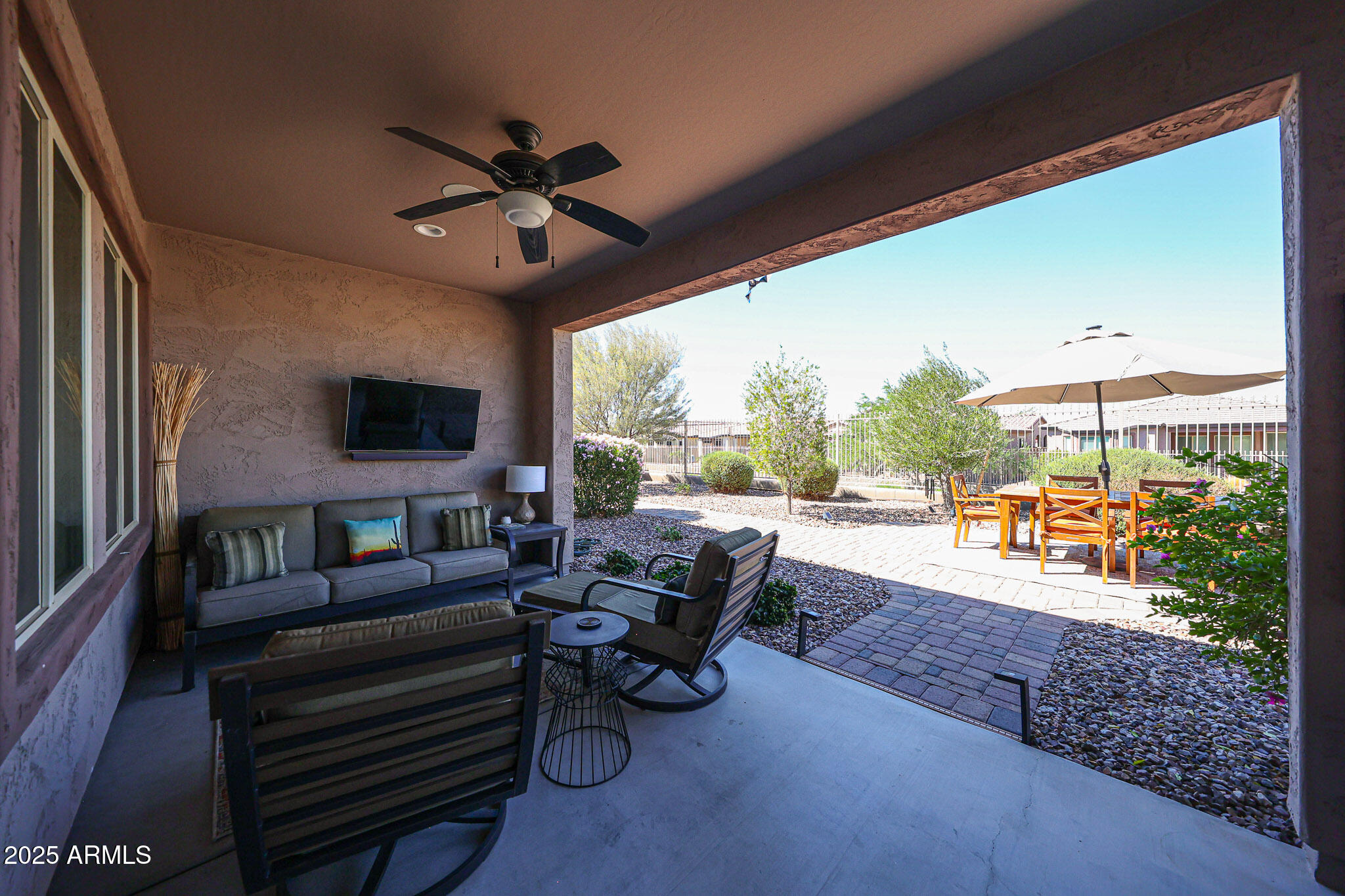 18184 West Deer Creek Road Goodyear, AZ 85338 - Photo 49 of 82 a living room with patio furniture and a floor to ceiling window