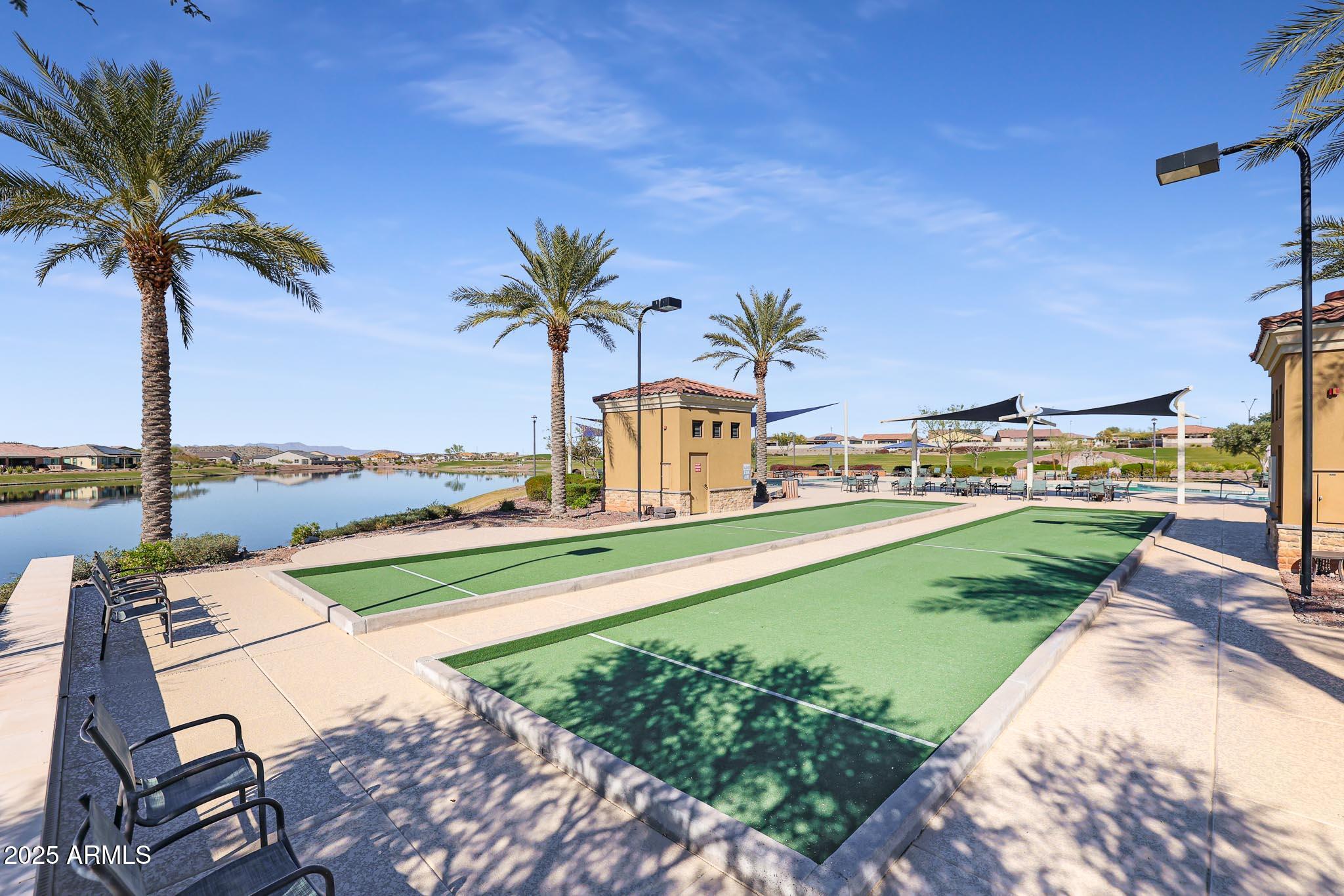 18184 West Deer Creek Road Goodyear, AZ 85338 - Photo 72 of 82 a view of a swimming pool with a lawn chairs under an umbrella