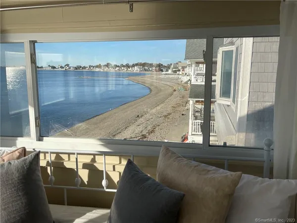 a living room with couches and kitchen view with wooden floor