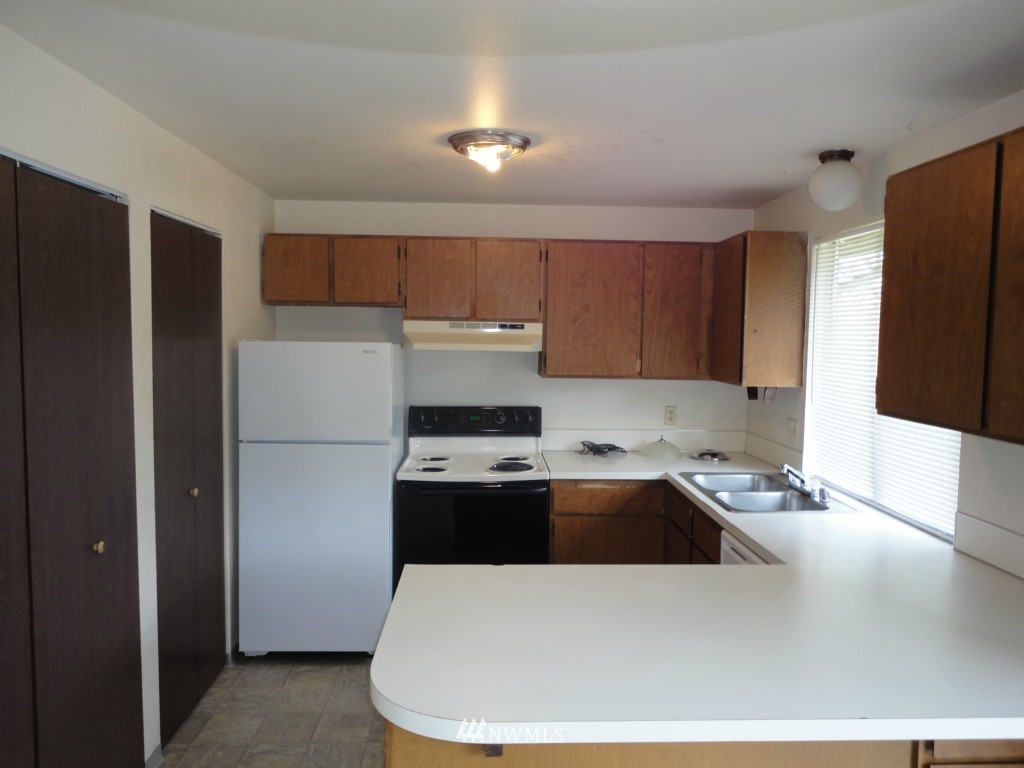 3901 Mason Loop Road Tacoma, WA 98409 - Photo 4 of 12 a kitchen with a refrigerator and a sink