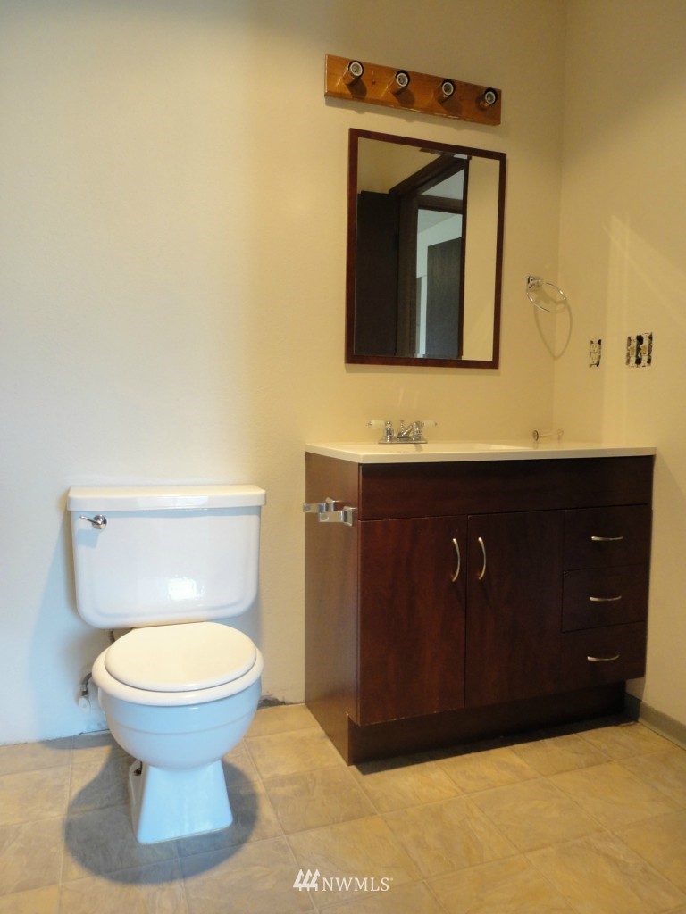 3901 Mason Loop Road Tacoma, WA 98409 - Photo 9 of 12 a bathroom with a toilet sink and mirror