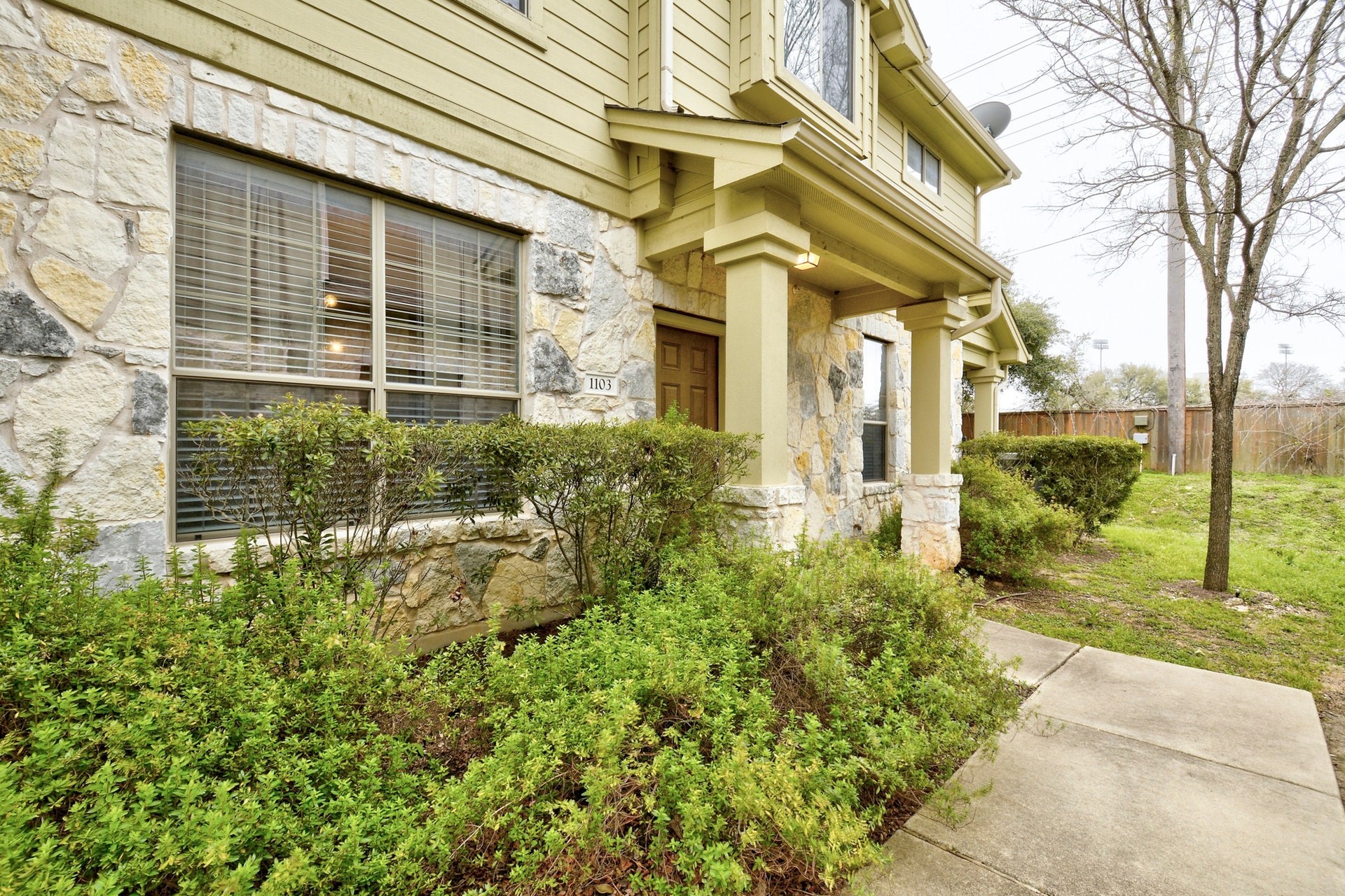 14815 Avery Ranch Boulevard, Unit 1103 Austin, TX 78717 - Photo 2 of 25 a view of a brick house with a large windows and plants