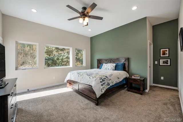 a spacious bedroom with a large bed and a chandelier