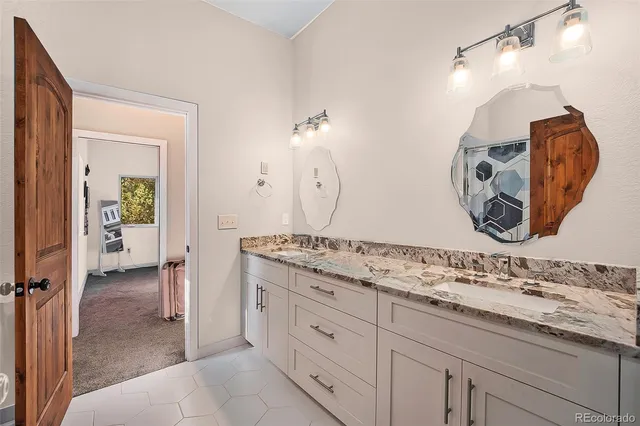 a spacious bathroom with a granite countertop sink and a mirror