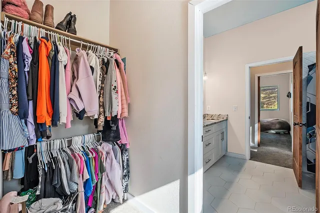 a view of walk in closet with clothes