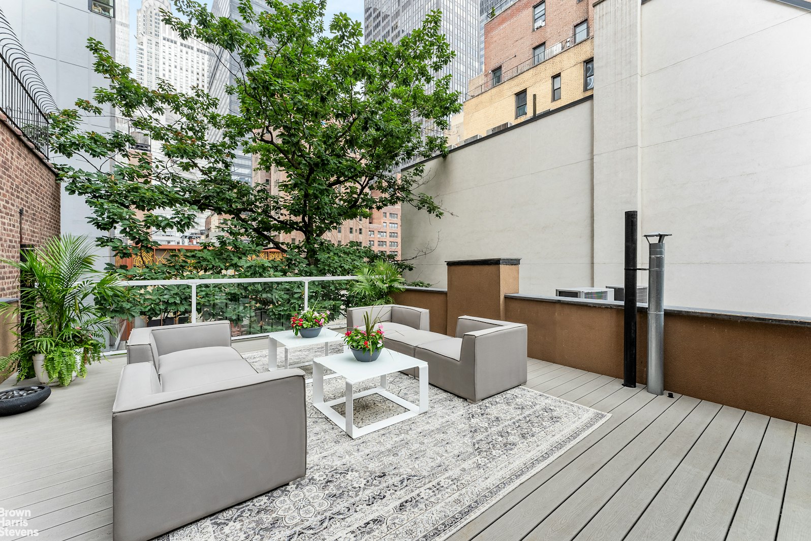 131 East 38th Street Manhattan, NY 10016 - Photo 17 of 26 a view of a deck with couches table and chairs with wooden floor