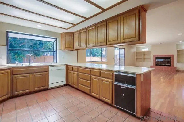 a view of an empty room with wooden floor and fan