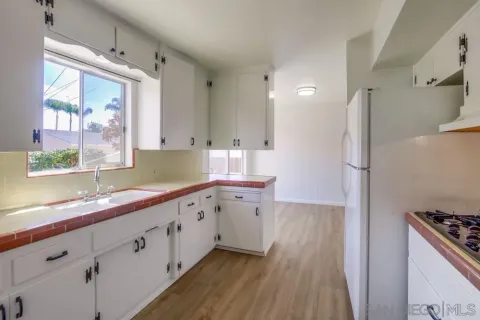 a view of an empty room with wooden floor and closet
