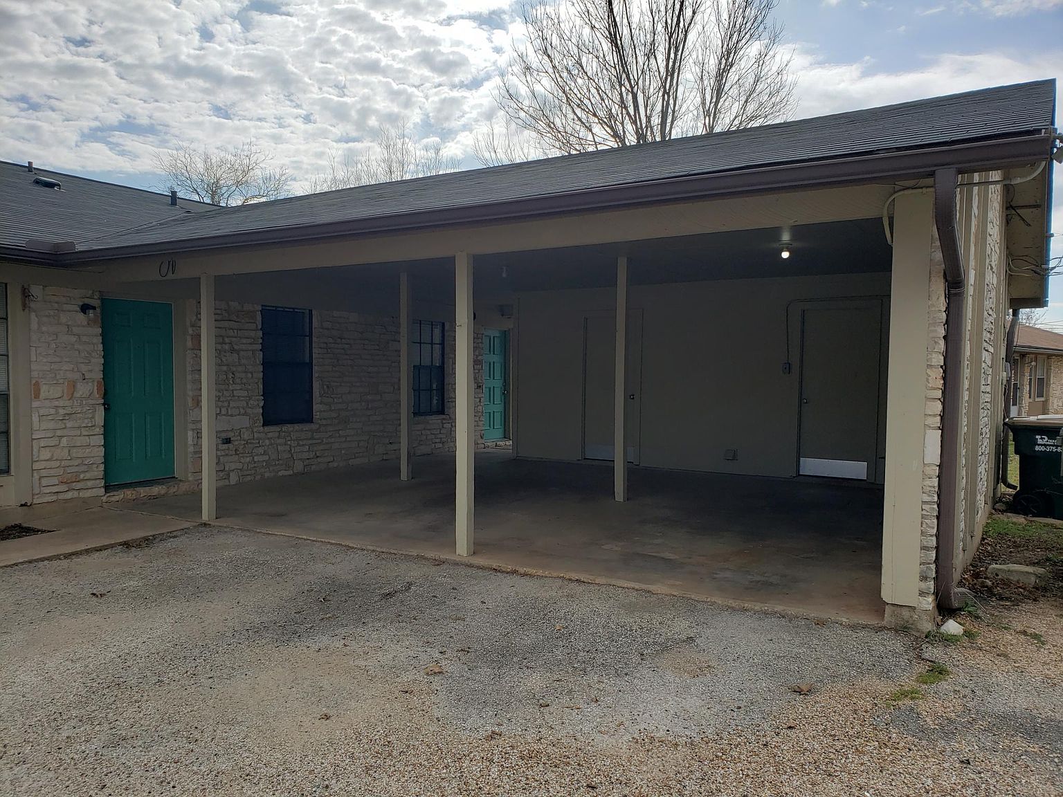 802 Ranch Road, Unit A Georgetown, TX 78628 - Photo 11 of 11 A sheltered carport offers convenient, covered parking adjacent to a charming stone-faced structure.