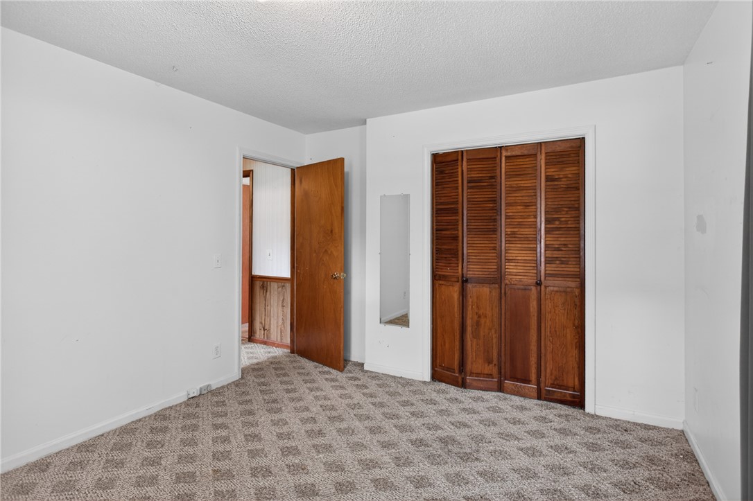 112 Holliday Lane Pendleton, SC 29670 - Photo 25 of 42 A cozy bedroom features patterned carpet and bi-fold wooden closet doors.