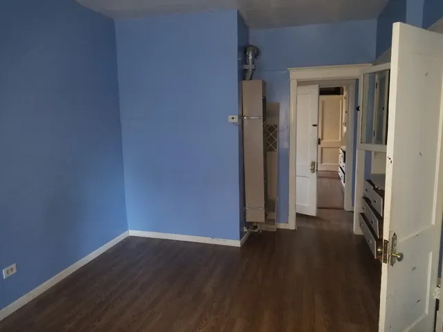 an empty room with wooden floor and a window