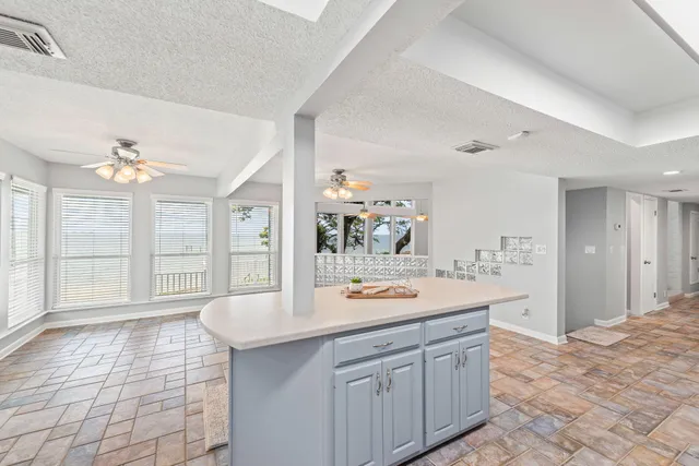 an empty room with windows and fan