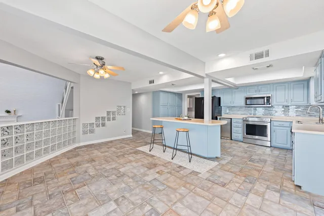 an empty room with a ceiling fan and wooden floor