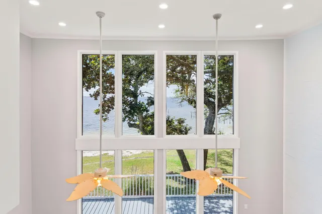 a front view of a house with garden and trees