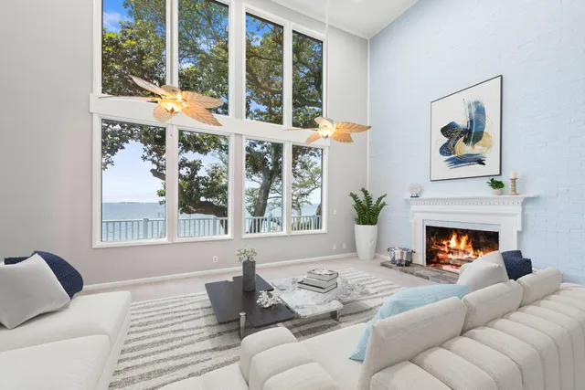 a living room with furniture a fireplace and a large window