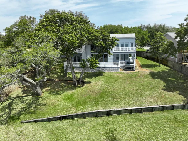 a front view of a house with a garden and tree