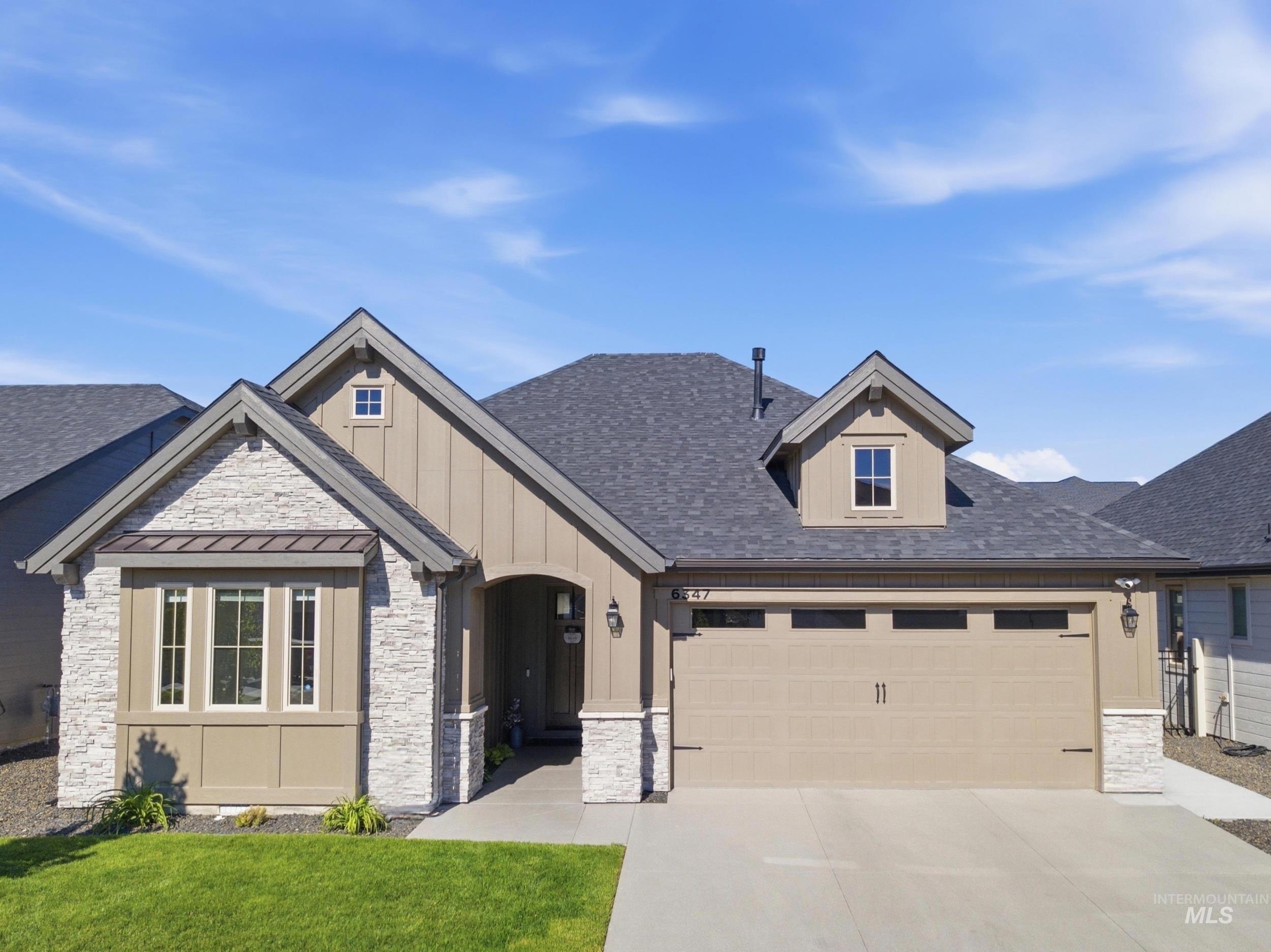 6347 South Utmost Lane Meridian, ID 83642 - Photo 1 of 37 Contemporary exterior with a stone facade accent, an attached two-car garage, a covered entry, multiple gables, and a manicured front lawn
