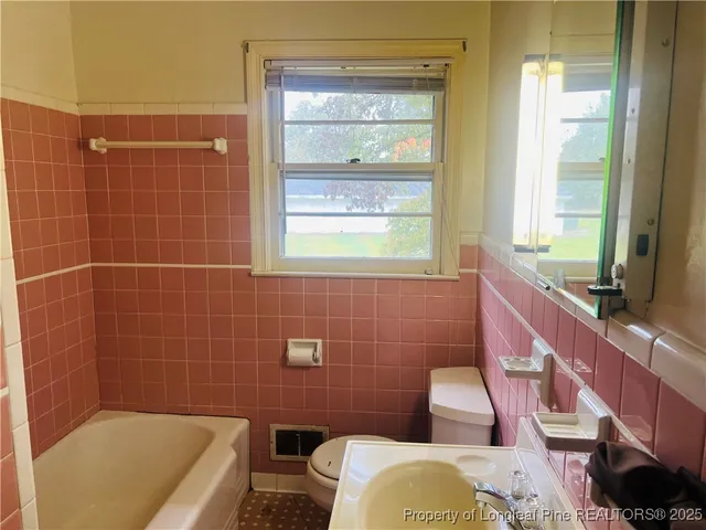 a bathroom with a sink a toilet a mirror and bathtub