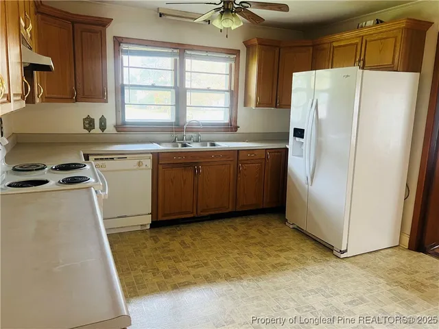 a kitchen with granite countertop a refrigerator and a sink