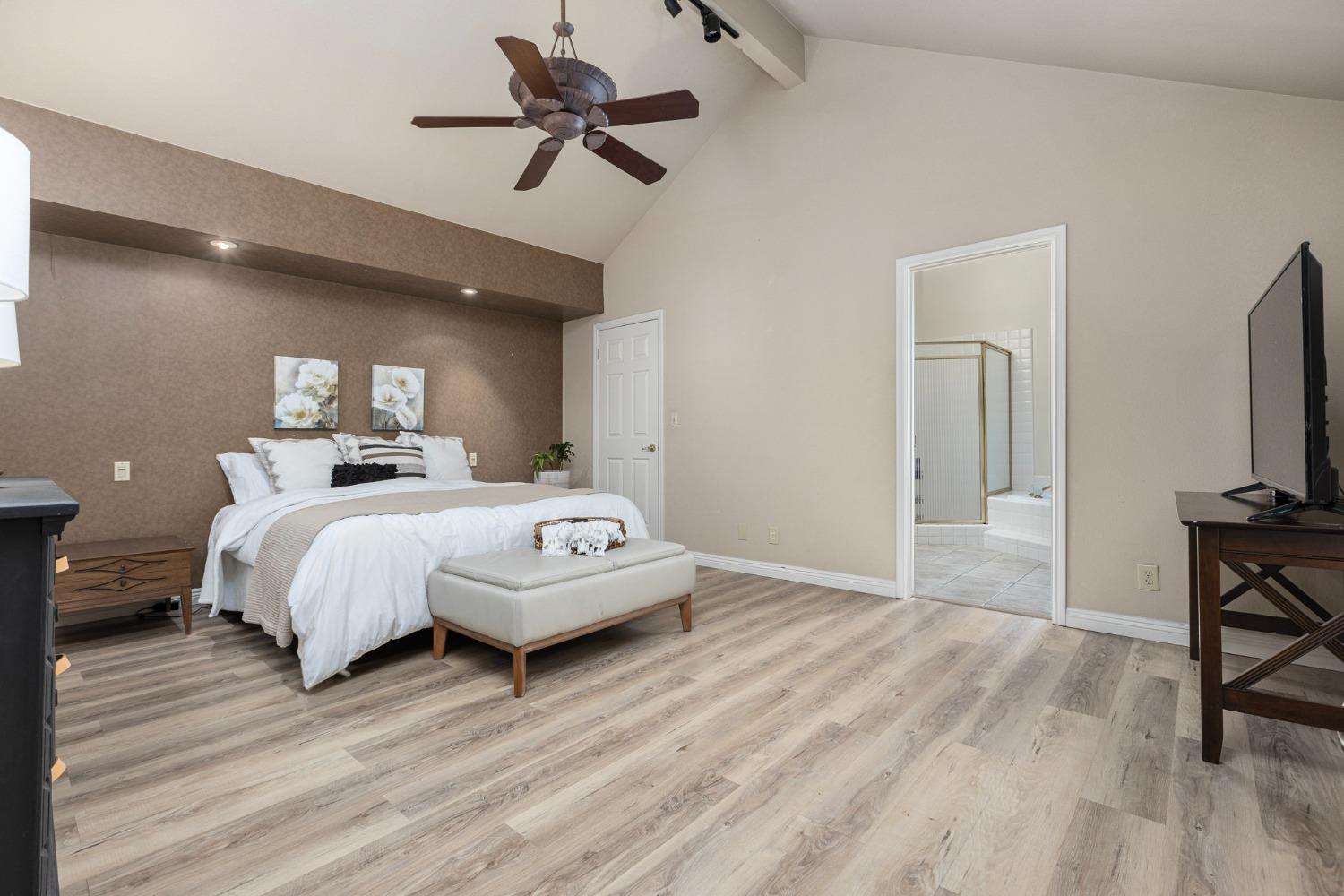 2128 Swift Avenue Clovis, CA 93611 - Photo 14 of 25 a bedroom with a bed a large window and wooden floor