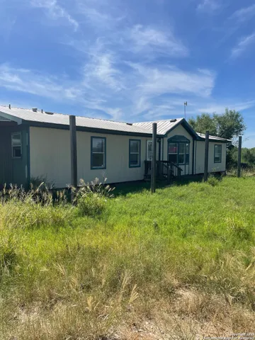 a view of a house with a yard and sitting area