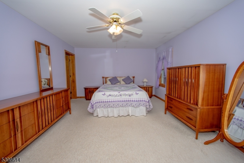 171 Mt Salem Road Wantage, NJ 07461 - Photo 14 of 38 a spacious bedroom with a bed and a chandelier