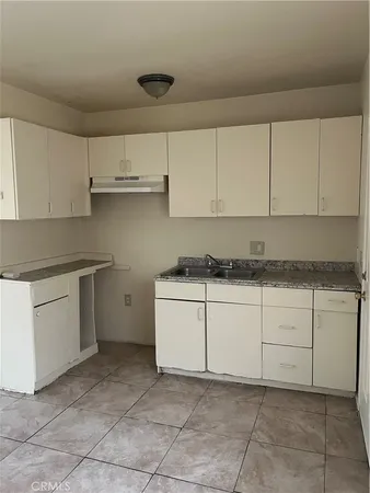 a kitchen with cabinets oven and a sink