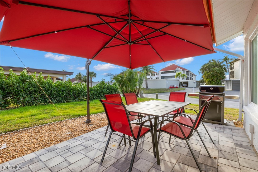 11545 Cinnamon Cove Boulevard Fort Myers, FL 33908 - Photo 26 of 26 a patio with a table and chairs under an umbrella